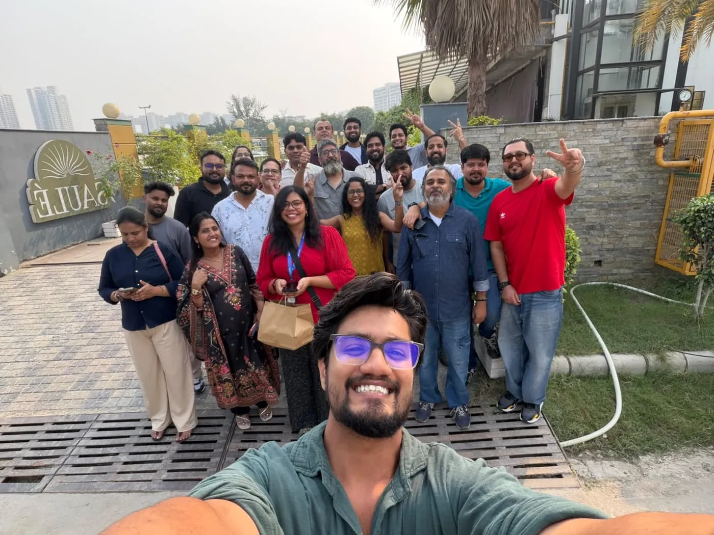 A selfie of Anuraj with a large group of colleagues outdoors